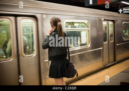 " Commuter " attende come un treno della metropolitana entra la Fulton Street station in Lower Manhattan a New York Foto Stock