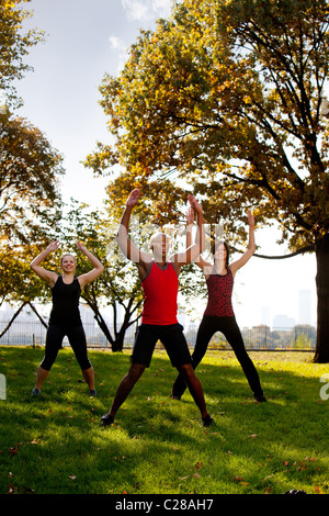 Un gruppo di persone facendo Jumping Jack nel parco Foto Stock