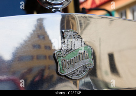 Maker del badge sul cofano del motore di un vecchio Asquith auto d'epoca, con edifici medievali si riflette nel chromework Foto Stock