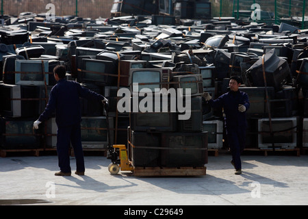 TV centro di riciclaggio dei lavoratori pila centinaia di televisori usati in un centro di riciclaggio in Hubei, Cina - 16.12.09 ** ** Foto Stock