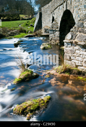 Il granito costruito il ponte di pietra a Postbridge su Dartmoor utilizzando slow shutter a velocità blur acqua fluente, DEVON REGNO UNITO Foto Stock