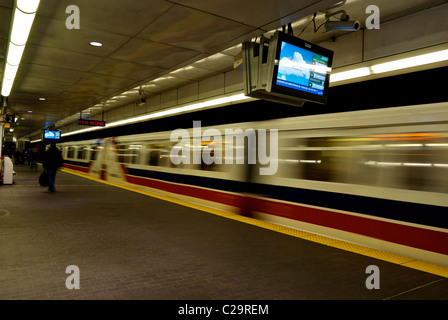 Translink Skytrain treni pendolari in motion blur lasciando sul lungomare di Vancouver LRT di " commuters " Stazione della metropolitana Foto Stock