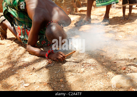 Un samburu tribesman messa a fuoco con due bastoncini Foto Stock