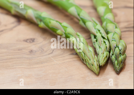 Gli asparagi Spears su un olive wood board Foto Stock