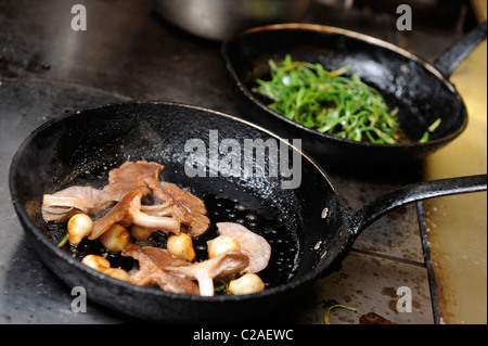 La cottura ocally foraged ingredienti tra cui rock Samphire (posteriore) e legno Blewit funghi (anteriore) presso il ristorante Foxhunter Foto Stock