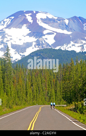 I ciclisti che viaggiano verso le sorelle montagna sopra la cascata Lakes National Scenic Byway Oregon Foto Stock