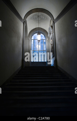 La tromba delle scale che conducono alla finestra vetrata, lampada pendenti dal soffitto Foto Stock