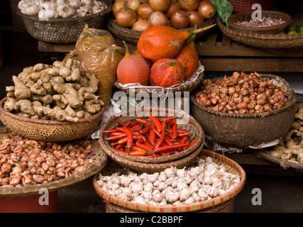 Cestini di frutta gac, peperoncino, cipolle, scalogni, zenzero e aglio in un mercato in Hanoi Old Quarter, Viet Nam Foto Stock