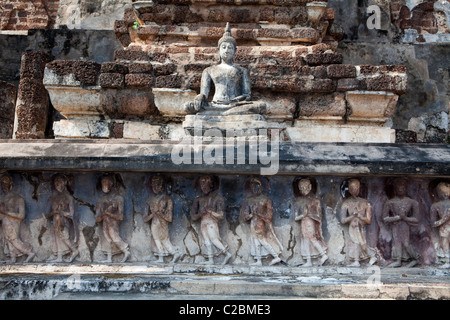 Il Buddha sotto i discepoli a fianco di Stupa in Sukhothai Historical Park Foto Stock