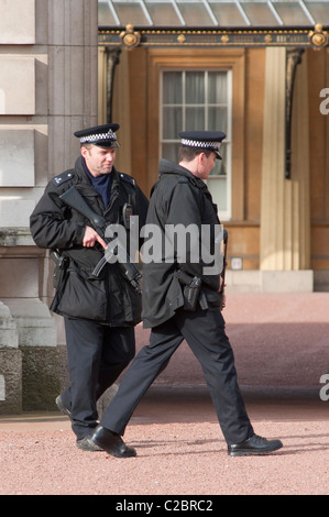 Gli ufficiali armati della Metropolitan Police vigore a Buckingham Palace a Londra, Inghilterra. Foto Stock