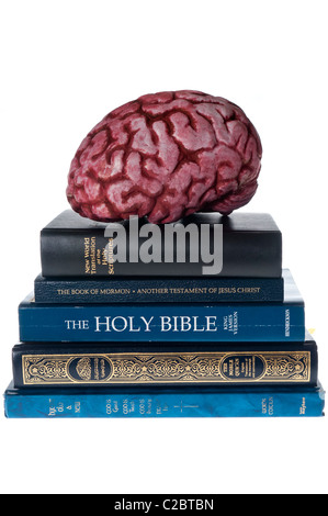 Modello di un cervello sulla parte superiore dei vari libri religiosi e Bibbie. Foto Stock