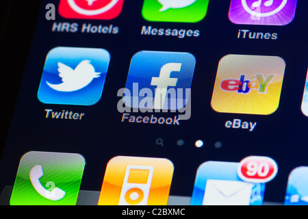 Dettaglio immagine macro di iphone touch screen. Il display mostra le applicazioni da facebook, twitter, ebay, itunes e messaggi Foto Stock