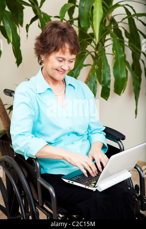 Disabilitato imprenditrice utilizzando un piccolo computer netbook. Foto Stock