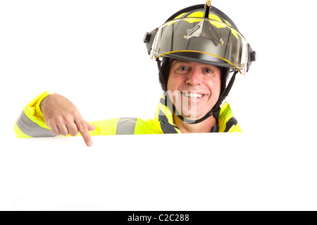 Cordiale vigile del fuoco in uniforme, rivolta verso lo spazio vuoto e bianco, pronto per il tuo messaggio. Foto Stock