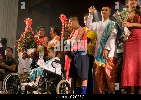 Un gruppo di disabili uomini e donne sono riconoscendo saluti da un pubblico dopo una performance musicale in Vientiane, Laos. Foto Stock