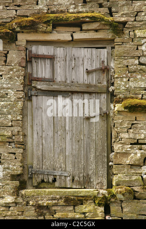 Porta di legno nel lato del vecchio abbandonati fienile in pietra. Foto Stock