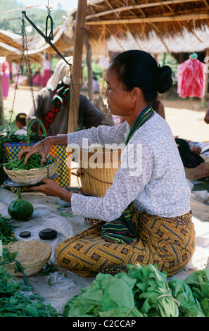 Donna in sarong pesando verdura, Lago Inle, Stato Shan, Myanmar, Asia Foto Stock