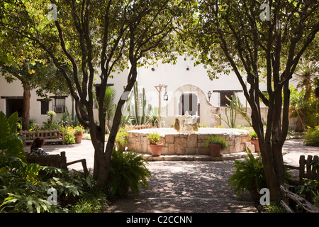 Donna seduta nel cortile ombreggiato spagnolo nel Palazzo del Governatore San Antonio Texas USA Foto Stock