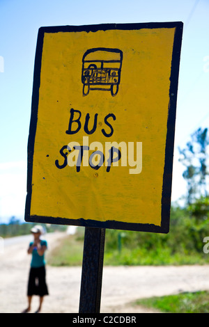 Una solitaria figura attende un bus in Belize. Foto Stock