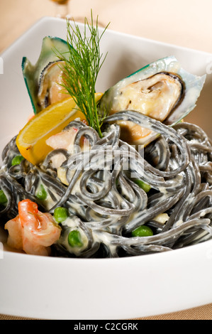 Piatti a base di frutti di mare freschi nero seppia coulored spaghetti tipico cibo italiano