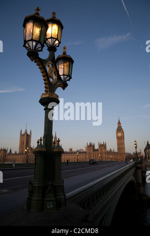 Lampada lite fino al mattino presto sul Westminster Bridge con le case del Parlamento nel retro di massa. Foto Stock