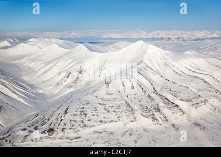 Una coperta di neve mountain range in Svalbard Foto Stock