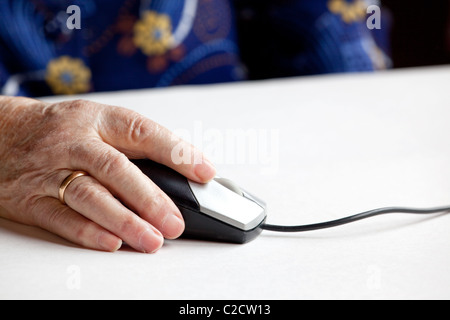 Un anziano mano sul mouse di un computer Foto Stock