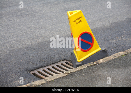 Polizia di Wiltshire, nessun cono di parcheggio, nessuna attesa accanto al coperchio di scarico in strada a Wiltshire, Regno Unito Foto Stock