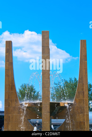 Fontana di acqua contro il cielo blu e alberi Foto Stock