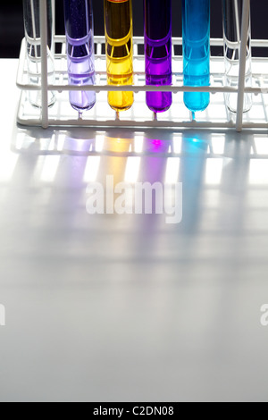 Rack di sei provette in un laboratorio di contenimento di liquidi in vari colori Foto Stock