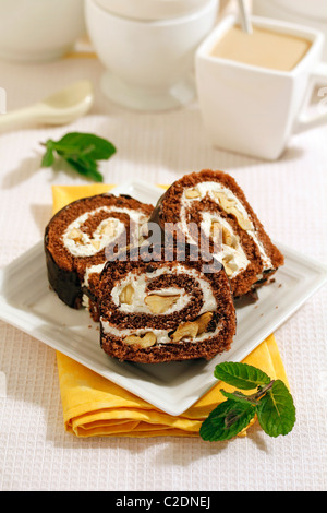 Il cioccolato rotolo svizzero con noci. Ricetta disponibile. Foto Stock