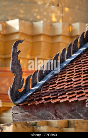 Il bordo della grondaia decorazione in Thailandia tempio, per lo più in pietra o cemento ma questo vecchio tempio di legno. Foto Stock