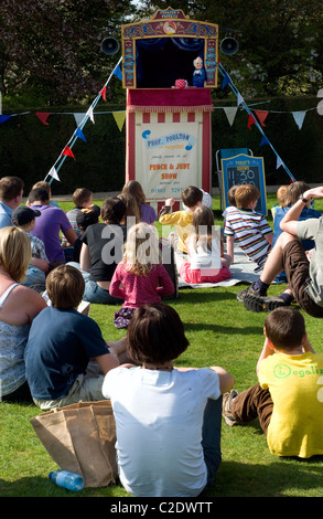 I bambini e le famiglie a guardare il Professor Poultons Inglese tradizionale con punzone e Judy show, poliziotto, figli, genitori, stand,E Foto Stock