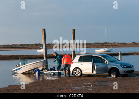 Il caricamento di una barca su un rimorchio per auto alla fine della giornata sulla Costa North Norfolk Foto Stock