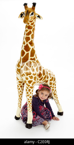 Bambina che gioca con il giocattolo farcito giraffa Foto Stock