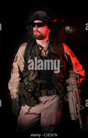 Un moody colpo di un US Special Forces soldier di notte illuminata da proiettori bianco rosso e la spia di avvertimento. L'Afghanistan. L'Iraq. Foto Stock