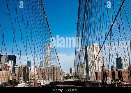 La parte inferiore di Manhattan cityscape visto dal Ponte di Brooklyn percorso con la disposizione dei cavi web-simili pattern, New York City, Stati Uniti d'America Foto Stock