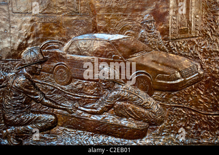 Dettaglio del New York Fire Department NYFD Memorial Wall bassorilievo in bronzo che mostra i vigili del fuoco e un'auto a Ground Zero, Manhattan, New York. Foto Stock