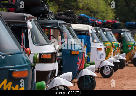 Pimped fino Tuk tuks line up per la partenza il rickshaw esecuzione in India Foto Stock