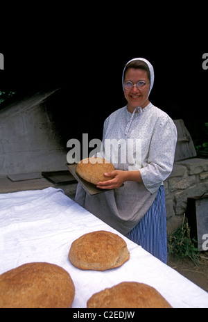 1, una donna canadese indossando costumi d'epoca, la cottura del pane, Acadian Historical Village, vicino alla città di Caraquet, New Brunswick Provincia, Canada Foto Stock