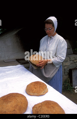1, una donna canadese indossando costumi d'epoca, la cottura del pane, Acadian Historical Village, vicino alla città di Caraquet, New Brunswick Provincia, Canada Foto Stock