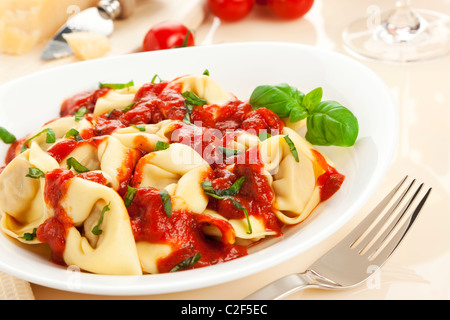 Tortelloni il piatto con il basilico e la salsa di pomodoro, vista inclinato Foto Stock