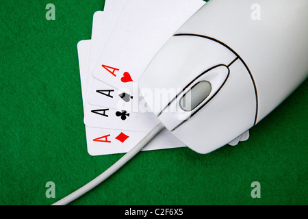 Un gioco online di concetto con il mouse del computer, quattro assi e feltro verde Foto Stock