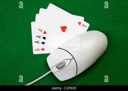 Un gioco online di concetto con il mouse del computer, quattro assi e feltro verde Foto Stock