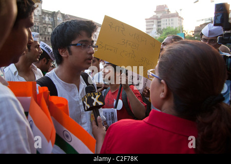 Una signora giovane sostenitore di Anna Hazare per la campagna contro la corruzione essendo intervistato da un canale TV all Azad Maidan, India. Foto Stock