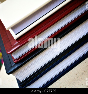 Libri con diversi colori di coperchi impilati uno sull'altro. Foto Stock