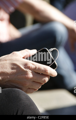 Dettaglio della donna tenendo iphone in Sun all'aperto Foto Stock