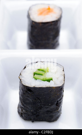 Due Kappa Maki cetriolo Giapponese e Sushi di Salmone rotoli con alghe nero su un piatto bianco Foto Stock