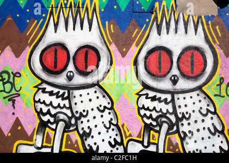 Graffiti o di arte di strada sulla parete di due civette, Princelet Street, Off Brick Lane, Londra, E1, Regno Unito Foto Stock