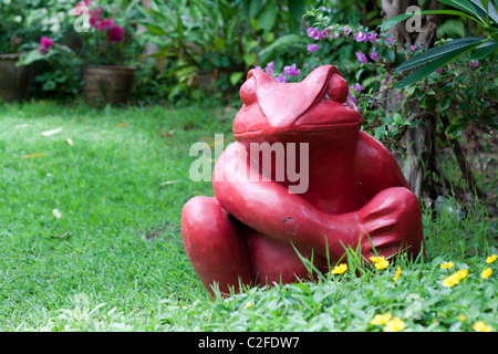 Red statua rana in un giardino estivo Foto Stock